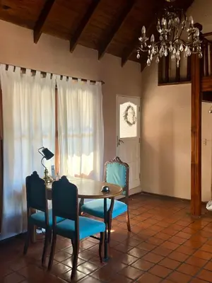 a dining room with a table and blue chairs at Posada Novalis in Villa General Belgrano