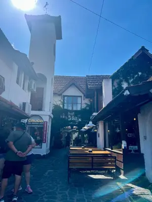 a person standing next to a bench in a street at Posada Novalis in Villa General Belgrano