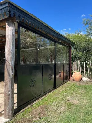 a green garage with glass doors in a yard at Cobiche in Villa Larca