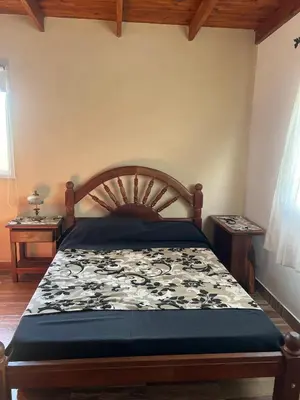 a bedroom with a bed with a wooden headboard at Cobiche in Villa Larca