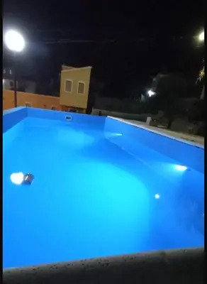 a large blue swimming pool at night at casa carlos paz in Villa Carlos Paz