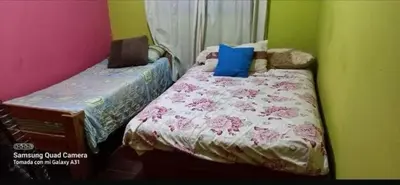 a bedroom with a bed with pink and green walls at casa carlos paz in Villa Carlos Paz