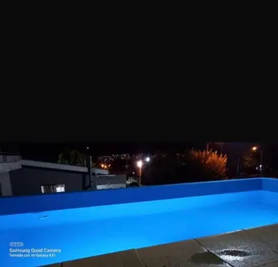 a blue swimming pool at night in a city at casa carlos paz in Villa Carlos Paz