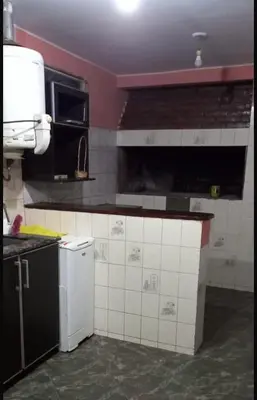 a kitchen with a stove and a sink and a refrigerator at casa carlos paz in Villa Carlos Paz