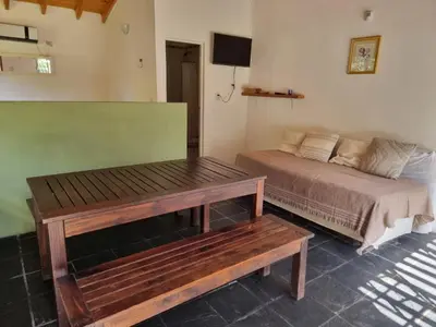 a bedroom with a bed and a wooden table at Casitas Santa Elena in Trapiche
