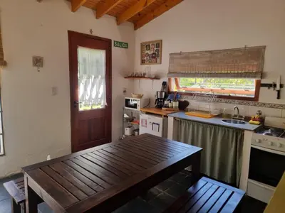 a kitchen with a wooden table and a sink at Casitas Santa Elena in Trapiche