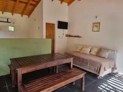 a bedroom with a bed and a wooden table at Casitas Santa Elena in Trapiche