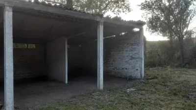 an empty brick building with pillars in a field at Las Vertientes in Tanti