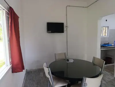 a room with a table and chairs and a television at Las Vertientes in Tanti