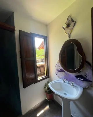 a bathroom with a sink and a mirror on the wall at Casa rústica y departamento con wifi, cochera y asador a metros del río Mina Clavero in Mina Clavero