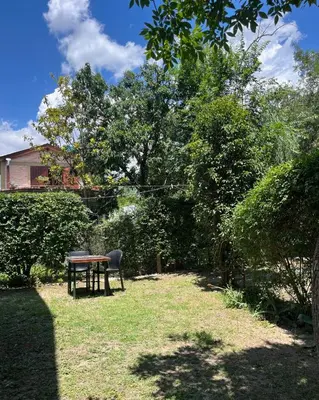 a picnic table and a chair in a yard at Casa rústica y departamento con wifi, cochera y asador a metros del río Mina Clavero in Mina Clavero