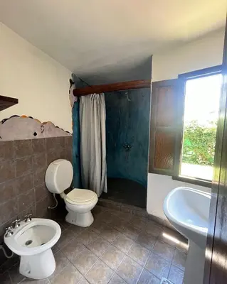 a bathroom with a toilet and a sink at Casa rústica y departamento con wifi, cochera y asador a metros del río Mina Clavero in Mina Clavero