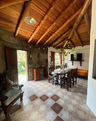 a large living room with a table and chairs at Casa rústica y departamento con wifi, cochera y asador a metros del río Mina Clavero in Mina Clavero