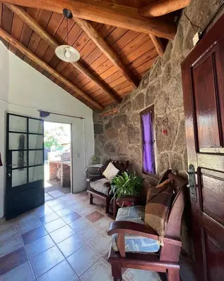 a living room with couches and a wooden ceiling at Casa rústica y departamento con wifi, cochera y asador a metros del río Mina Clavero in Mina Clavero