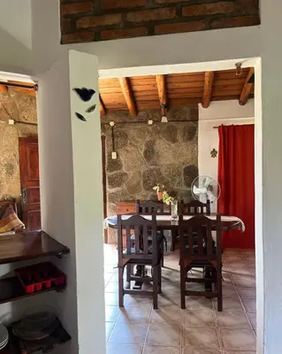 a kitchen and dining room with a table and chairs at Casa rústica y departamento con wifi, cochera y asador a metros del río Mina Clavero in Mina Clavero