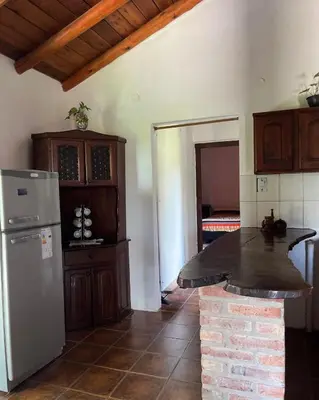 a kitchen with a refrigerator and a counter top at Casa rústica y departamento con wifi, cochera y asador a metros del río Mina Clavero in Mina Clavero