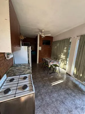 a kitchen with a stove and a table with chairs at Rincon de los cinco in Villa Cura Brochero