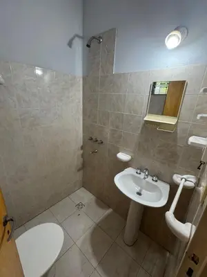 a bathroom with a sink and a toilet and a mirror at Rincon de los cinco in Villa Cura Brochero
