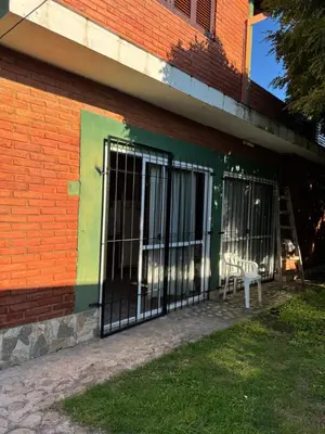 a building with doors and a white chair on the side at Rincon de los cinco in Villa Cura Brochero