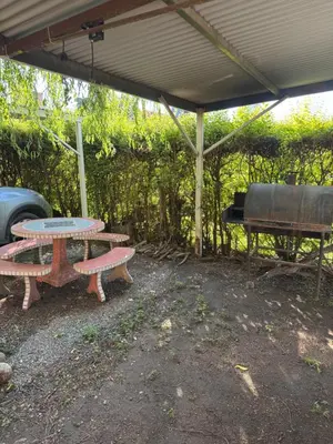a picnic table and a grill under a pavilion at Rincon de los cinco in Villa Cura Brochero