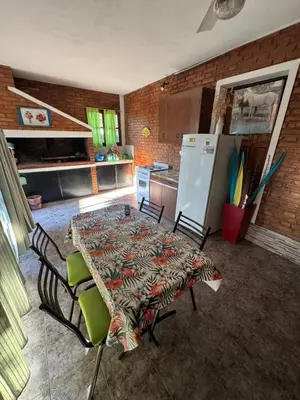 a kitchen with a table and chairs and a refrigerator at Rincon de los cinco in Villa Cura Brochero