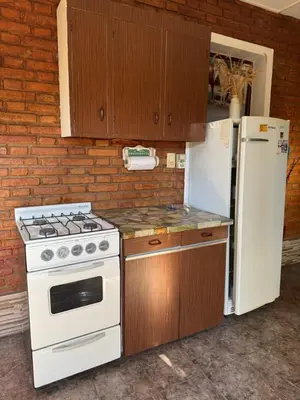 a kitchen with a stove and a refrigerator at Rincon de los cinco in Villa Cura Brochero