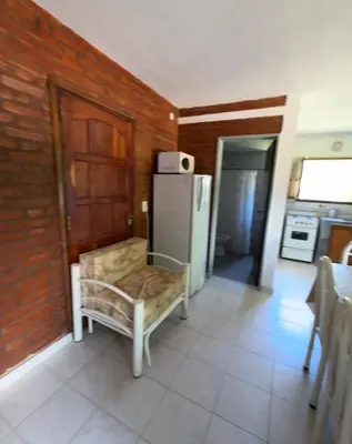 a kitchen with a chair and a refrigerator at Rincon de los cinco in Villa Cura Brochero