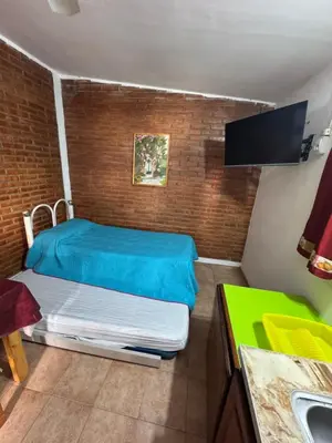 a bedroom with a large bed in a brick wall at Rincon de los cinco in Villa Cura Brochero