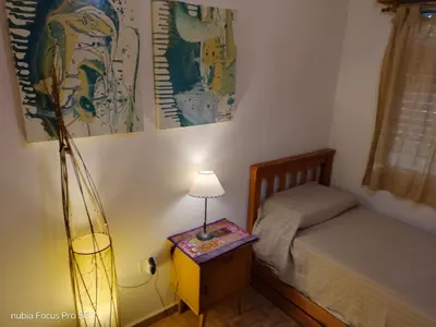 a bedroom with a bed and a table with a lamp at Marcelina in Villa Carlos Paz