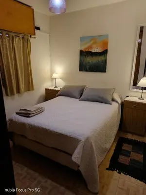 a bedroom with a bed and a painting on the wall at Marcelina in Villa Carlos Paz