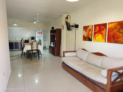 a living room with a white couch and a kitchen at Marcelina in Villa Carlos Paz