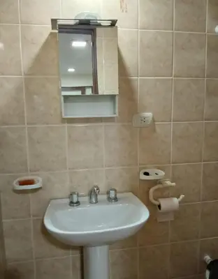 a bathroom with a sink and a mirror at La Pequeña Villa in Villa Carlos Paz