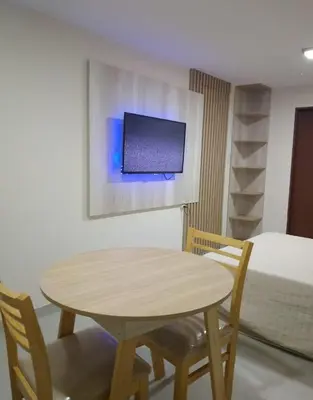 a table and chairs in a room with a bed at La Pequeña Villa in Villa Carlos Paz