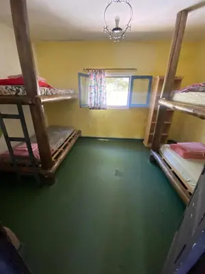 a room with three bunk beds and a green floor at Casa Kuku in Las Rabonas