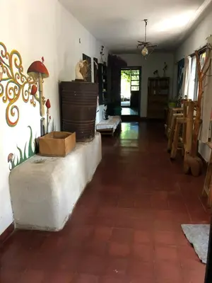 a living room with a tile floor and a room with a table at Casa Kuku in Las Rabonas