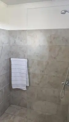 a shower with a glass door and a towel at Pasos del Dique in Cortaderas
