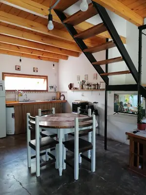a kitchen and dining room with a wooden table and chairs at Casita Santa Elena 1 in Trapiche