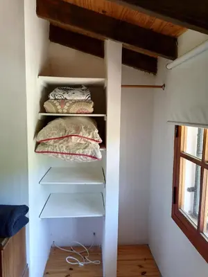 a walk in closet with white shelves and pillows at Casita Santa Elena 1 in Trapiche