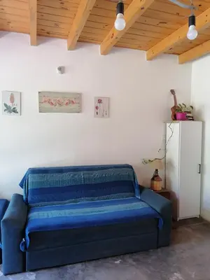 a blue couch in a room with a white wall at Casita Santa Elena 1 in Trapiche