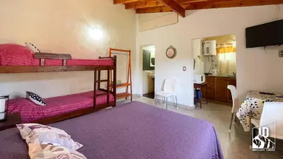 a bedroom with two bunk beds and a living room at Dos Soles in Cortaderas