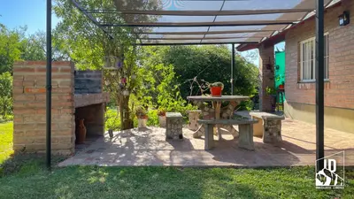 a patio with a picnic table and a fireplace at Dos Soles in Cortaderas