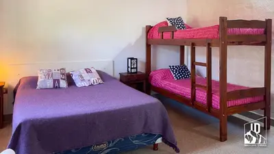 a bedroom with two bunk beds with purple sheets at Dos Soles in Cortaderas