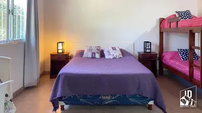 a bedroom with a purple bed with two bunk beds at Dos Soles in Cortaderas