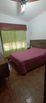 a bedroom with a large bed with a purple comforter at Casa Santa Rosa de Calamuchita in Cordoba