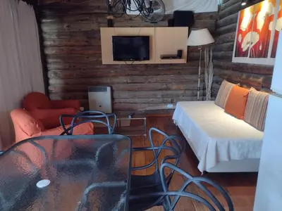 a living room with a bed and a tv at Cabañas de San Antonio in San Antonio de Arredondo