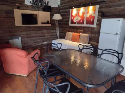 a dining room with a table and a couch at Cabañas de San Antonio in San Antonio de Arredondo