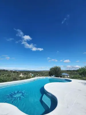 a swimming pool with a blue sky in the background at Balcones del Cristal - Tacuarita in Tanti
