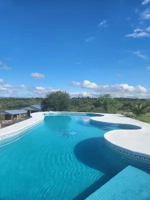 an infinity pool with blue water in a resort at Balcones del Cristal - Tacuarita in Tanti