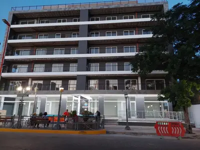 a large building with people sitting in front of it at Departamento Premium en el corazón de Villa Carlos Paz in Villa Carlos Paz