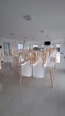 a row of white chairs in a room at Departamento Premium en el corazón de Villa Carlos Paz in Villa Carlos Paz